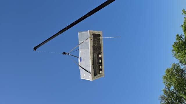 Lowering a new 40-ton system onto commercial property roof. 