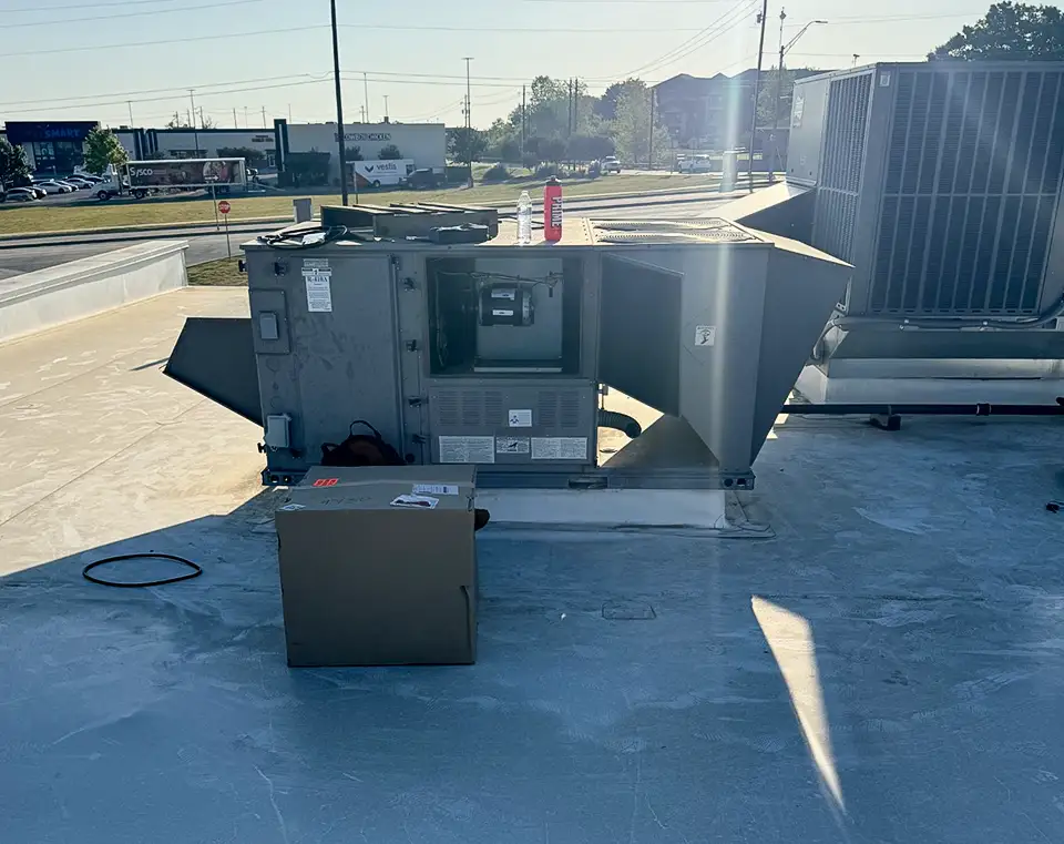 Cool Co Heating & Air works on a rooftop HVAC unit for a client.